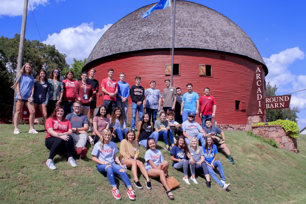 PLC students sit beside the Round Barn.