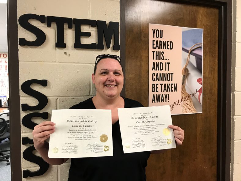 Seminole State College graduate Corie Carpenter proudly displays her two diplomas from the College – an Applied Science in Medical Laboratory Technology degree and an Associate in Science in Health Science degree.