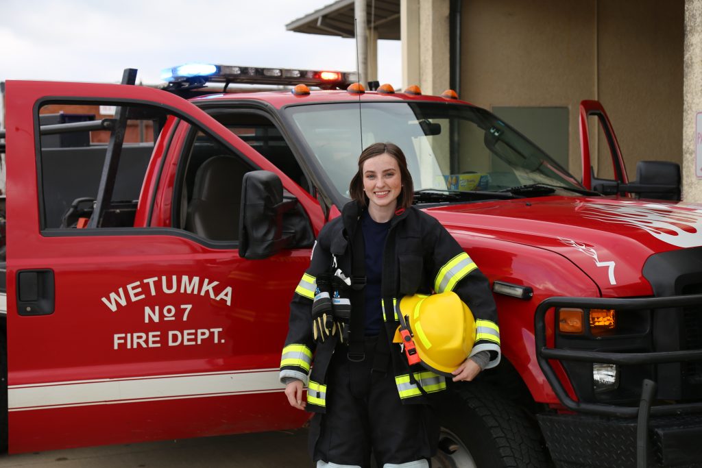 Randi Bray in front of a fire truck.