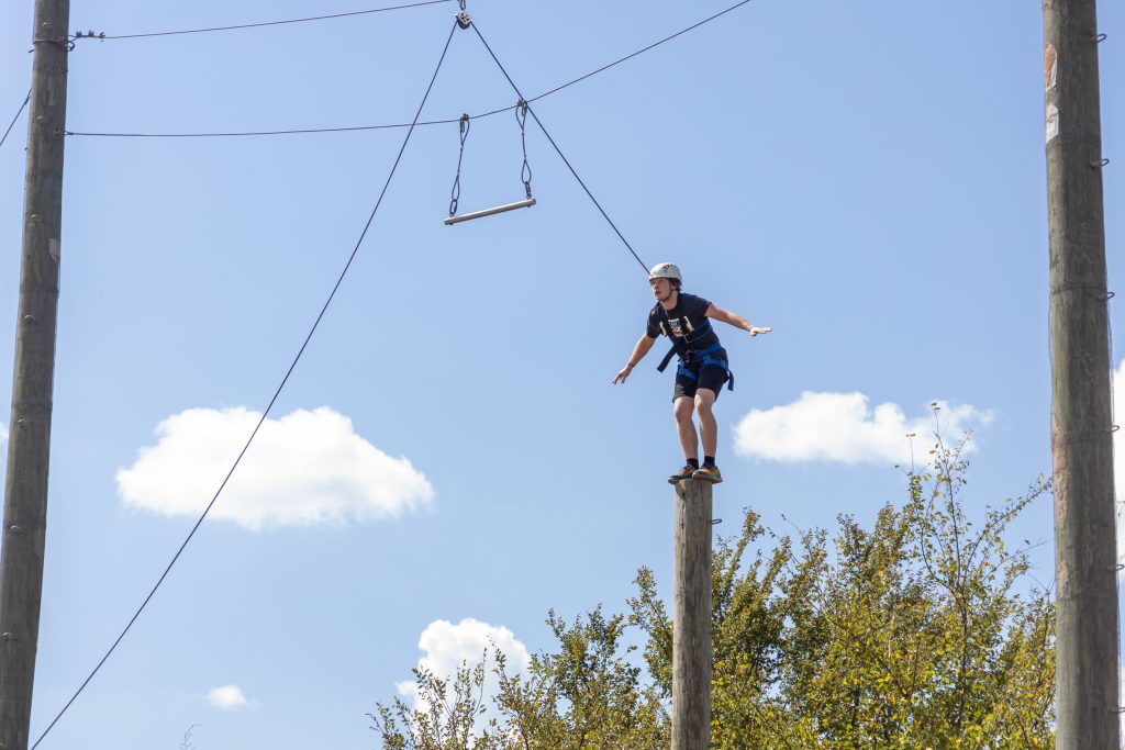 PLC student Frank Bourlon, of Shawnee, leaps from a tall pole to a power jump bar at St. Crispin’s Conference Center.