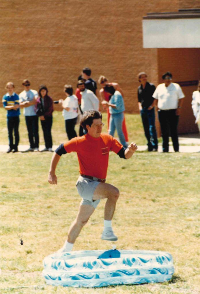 Longtime art instructor Kelly Kirk heads for the kiddie pool during an obstacle course race.