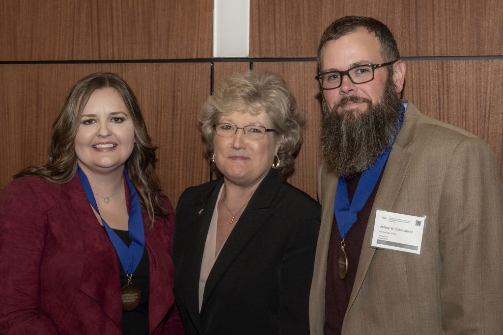 Outstanding Professional Staff Member Angela Harjo (left) and Outstanding Faculty Member Jeffrey Christiansen (right) pose for a photo with SSC President Lana Reynolds (center) at the OACC Annual Conference on Oct. 28 at Rose State College.