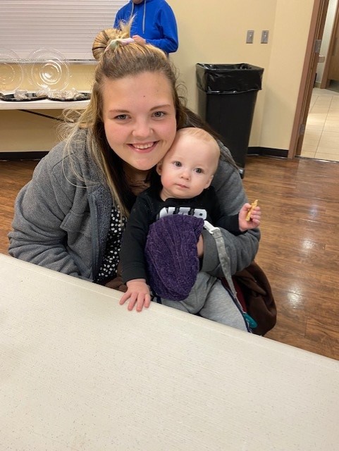 Alexus Corona, a fifth grade Shawnee teacher, mother of two and online student at Seminole State College, enjoys a warm break after viewing the lights at Snowman Wonderland with her 11-month-old son, Tyler, Monday night.