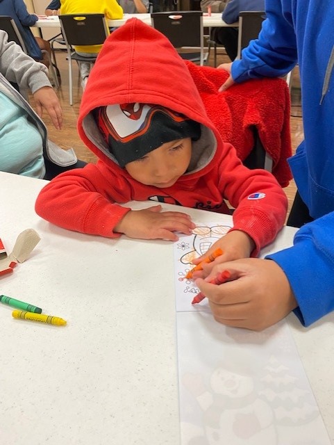 Koda Lindsey, age three, concentrates on his artwork Monday evening at the “SSC Night at the Lights” event.