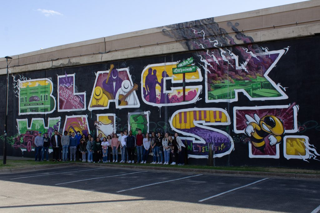 Members of the Seminole State College President’s Leadership Class pose for a photo in front of the 30-ft Black Wall St. mural located in Tulsa’s Greenwood District.