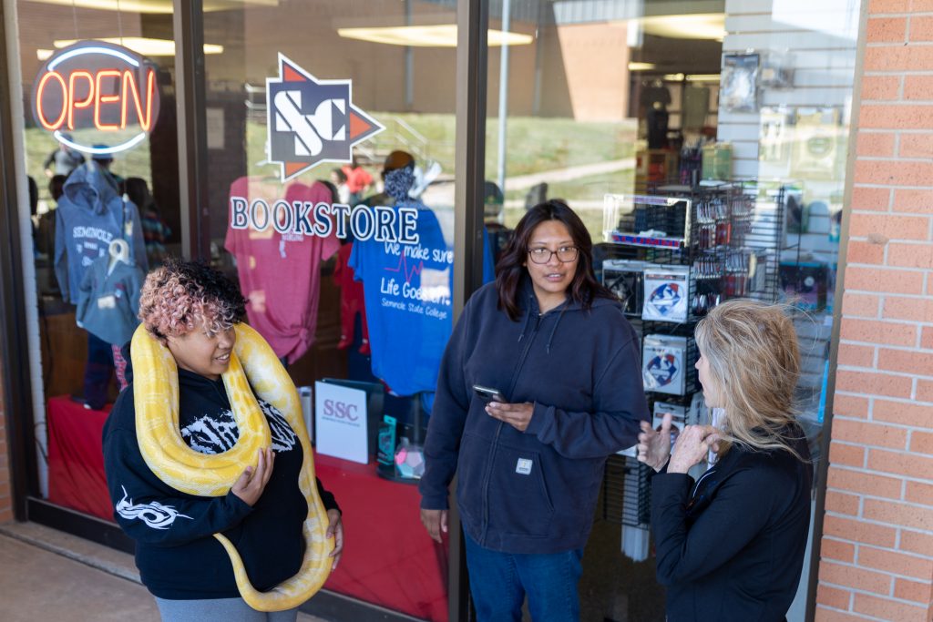 Melissa Meadows, owner of Extreme Animals, talks about the albino Burmese python named Cleopatra as a student holds on to the reptile.