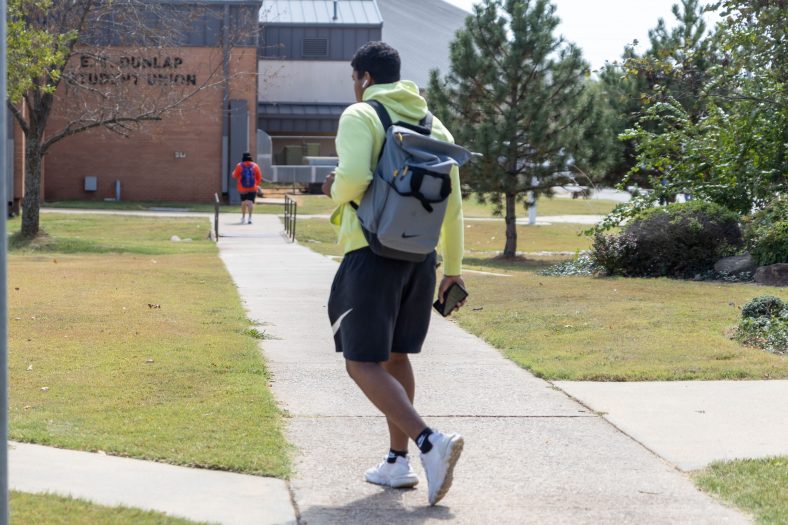A student is seen walking across campus between classes.