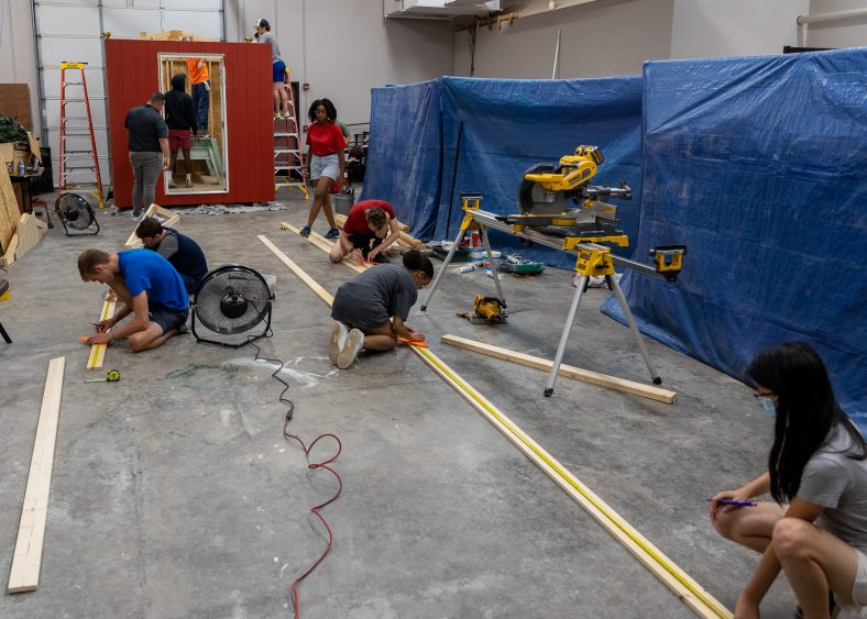 High school juniors and seniors are shown completing the construction of a tiny home during the Engineering and Construction Management camp at SSC.
