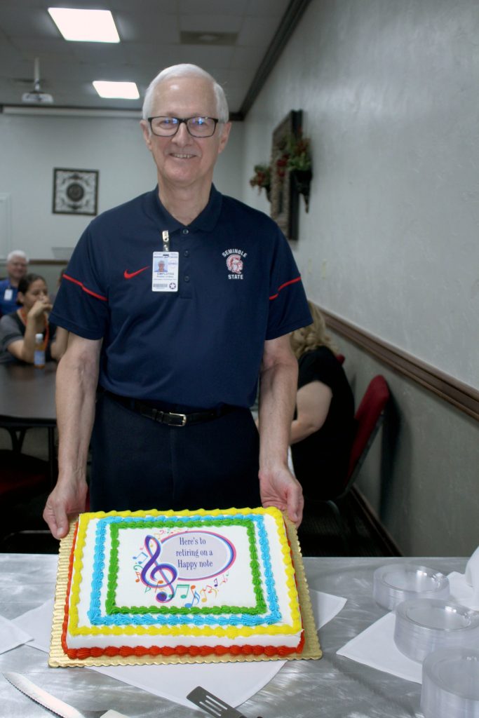 Seminole State College IT Technician Robbie Lindsey poses with his retirement cake.