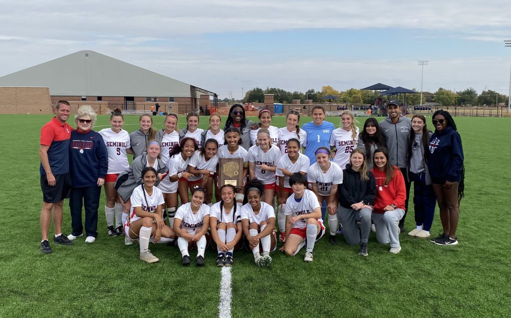 Pictured is the Seminole State College women’s soccer team alongside coach Dan Hill, and Seminole State college President Lana Reynolds (Standing together far left) posing after winning their fourth consecutive NJCAA Regional II title.