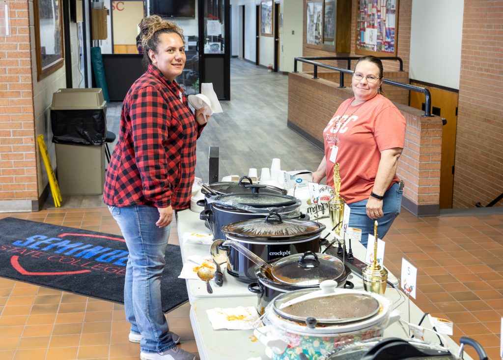 Financial Assistance Clerk Andrita Chavez and STEM Office Manager Dana Denwalt try out chili made by colleagues.