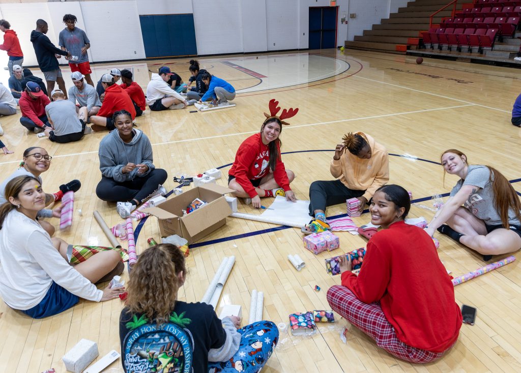 Seminole State College Athletes are shown wrapping gifts for the annual Earl Knowles free community Christmas dinner, organized by the Seminole Rotary Club.