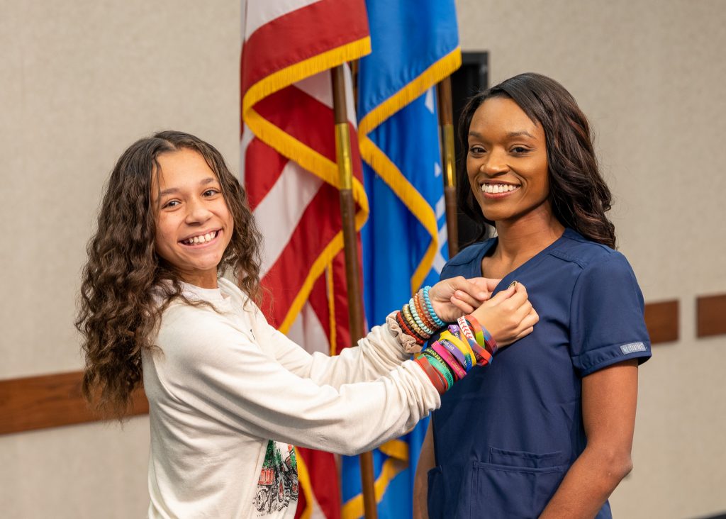 Jeanna Gordon (right) receives a nursing pin from her daughter, Harlow Evans (left), at the pinning ceremony on Dec. 8 at the Enoch Kelly Haney Center.