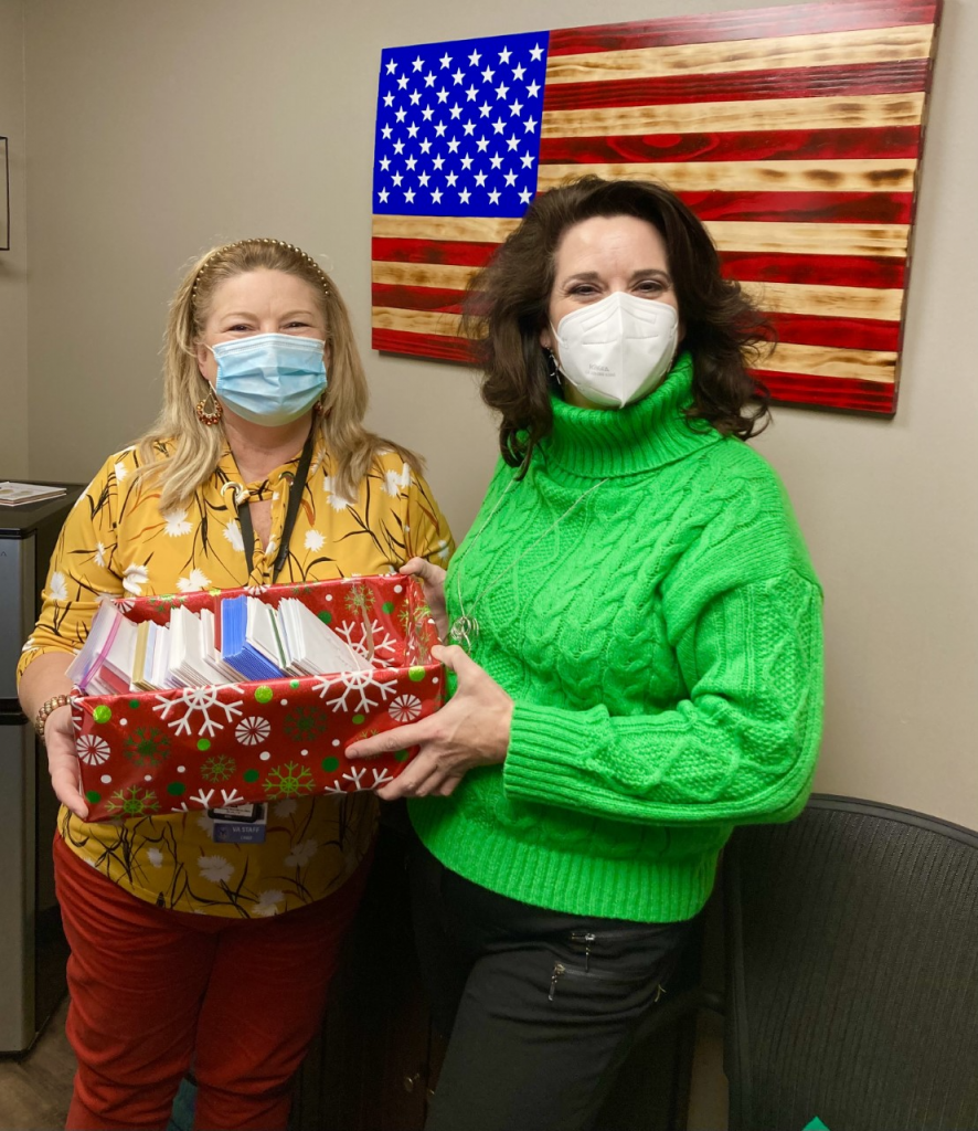 In this photo, Professor of History Marta Osby (right), who initiated this project and overseas it annually, delivers the Holiday Cards to Chief Melissa Overfield (left), who is in charge of Voluntary Services at the VA Hospital in OKC.