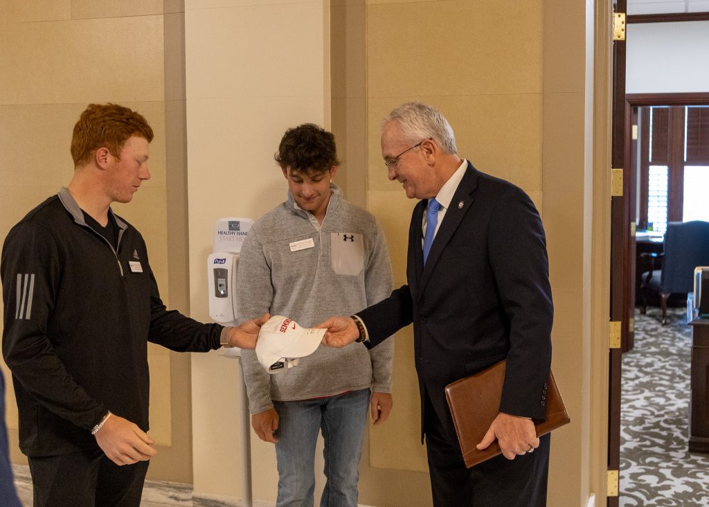 Taylon Laxson of Oklahoma City and Kaden Wright of Bixby, both freshmen members of the President’s Leadership Class and the Trojan Baseball Team, present Oklahoma State Senator Darcy Jech (R-Kingfisher) with an SSC baseball cap at the Capitol Tuesday. Sen. Jech is a member of the SSC Alumni Hall of Fame and played baseball for the Trojans during his time at the college.