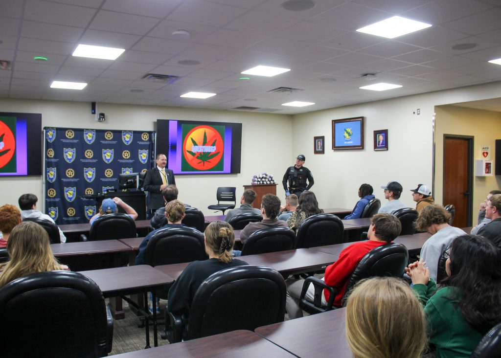 The Seminole State College President’s Leadership Class toured the Oklahoma Bureau of Narcotics and Dangerous Drugs in Oklahoma City on March 9. Mark Woodward (left), OBN Public Information and Education Officer, and Agent Anthony Moore (right) spoke with the students about a wide array of activities the OBN tackles, including the monitoring of marijuana grow operations in the state, safe disposal of prescription and illegal substances, as well as various training for officers within OBN.