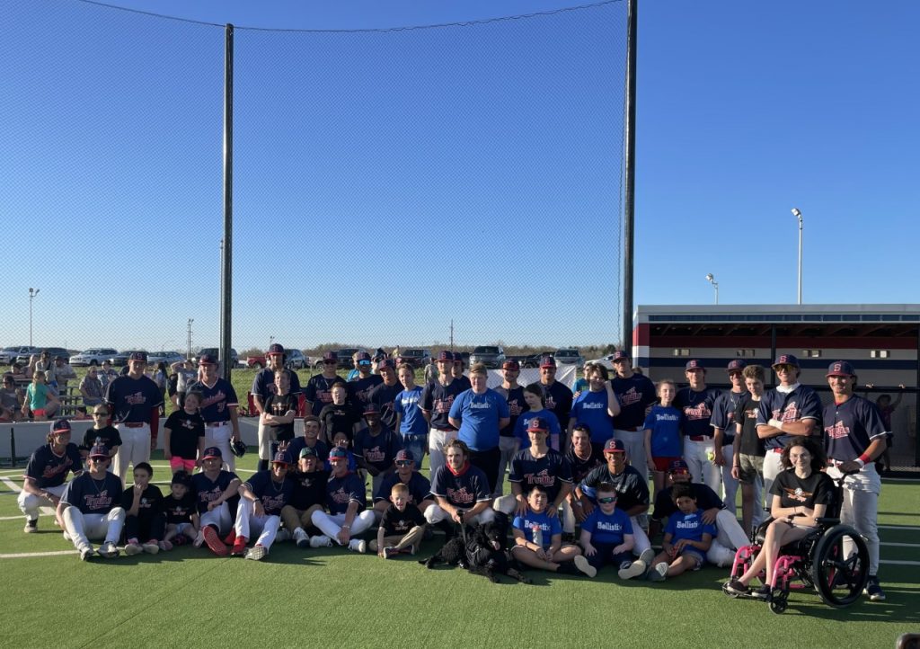 Nearly 40 participants, including Seminole State College Trojan baseball players, pose for a group photo during the season opener for “A League of Their Own,” a co-ed softball league established to provide an avenue for individuals with cognitive or physical disabilities to play baseball. 