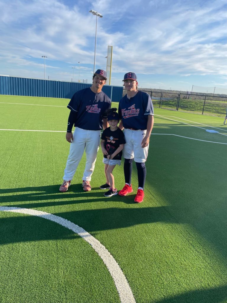 Parker Robinson (center), six, of Holdenville, enjoyed getting to play with SSC Trojans baseball players Beau Driggers (left) and Jameson Ross (right).