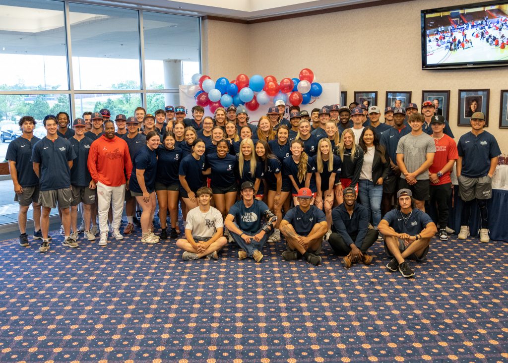 Baseball and softball teams pose for photo