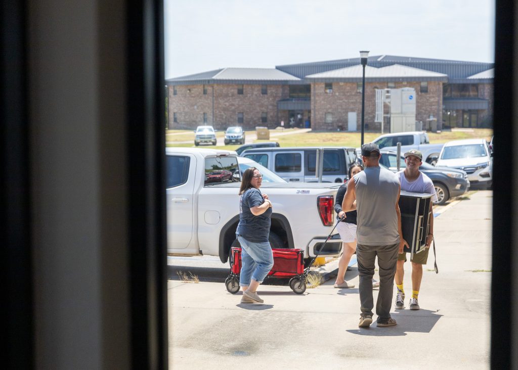 (Pictured) Students and parents are shown moving furniture into the dorm rooms.