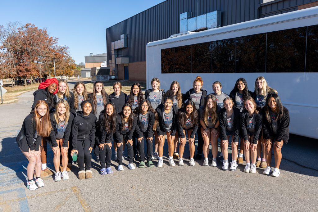 Pictured, the women’s soccer team poses in front of the bus before making their departure. 