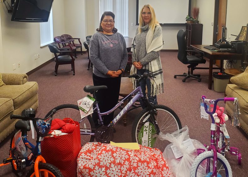 Pictured, Academic Affairs Administrative Assistant Tina Morris (left) and Student Affairs Administrative Assistant Toni Wittman (right) pose for a photo in front of gifts to be delivered.