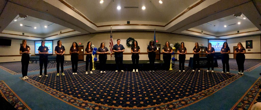 Nursing students expected to meet degree requirements this semester are pictured holding candles during this year's pinning ceremony.