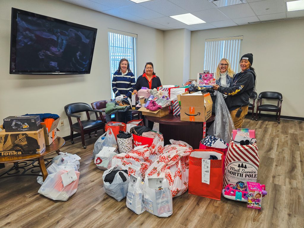 Posing for a group photo with gifts gathered for 25 children in need through the Salvation Army and the Oklahoma Department of Human Services, are (left to right): Language Arts and Social Sciences Office Manager Twila Kappele, Academic Affairs Administrative Assistant Tina Morris, Student Affairs Administrative Assistant Toni Wittmann, and Lead Custodian Christie McKee.