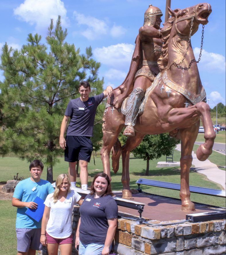 Pictured (L-R), Jake Robbins, Ft. Gibson; Kendra Hisaw, Stonewall; K.C. Bryan, Bowlegs; and Kaitlyn Trunk, Okemah stand together for a photo by the College’s Trojan Horse statue.