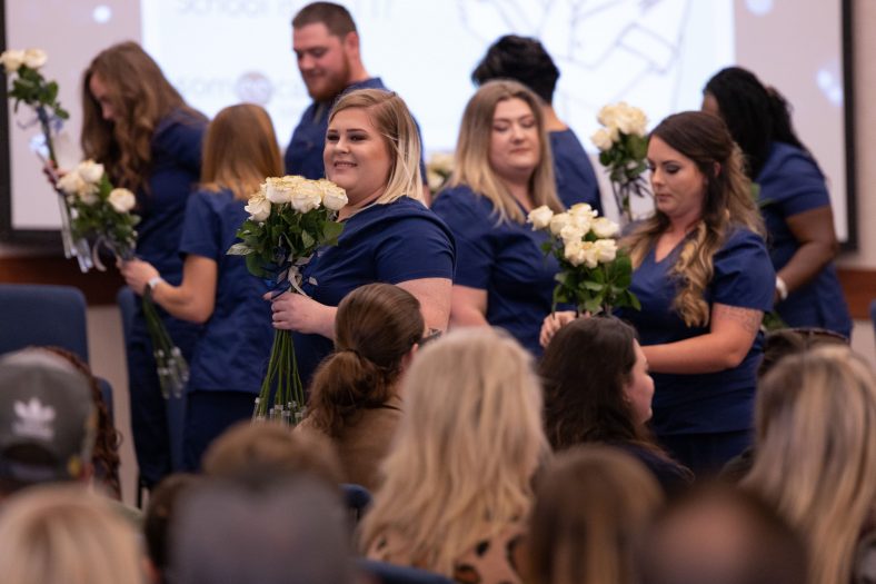 Seminole State College nursing students pass out flowers during the fall 2019 pinning ceremony. The nursing program recently received continued accreditation from the Accreditation Commission for Education in Nursing.