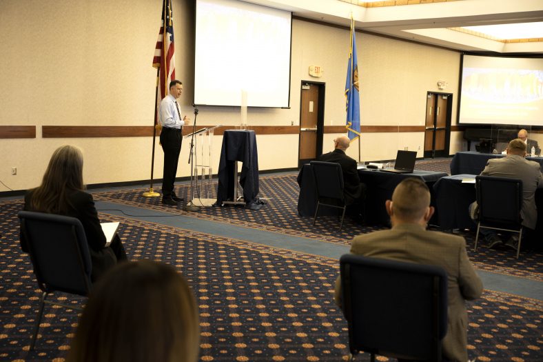 Man speaks to board meeting attendees.