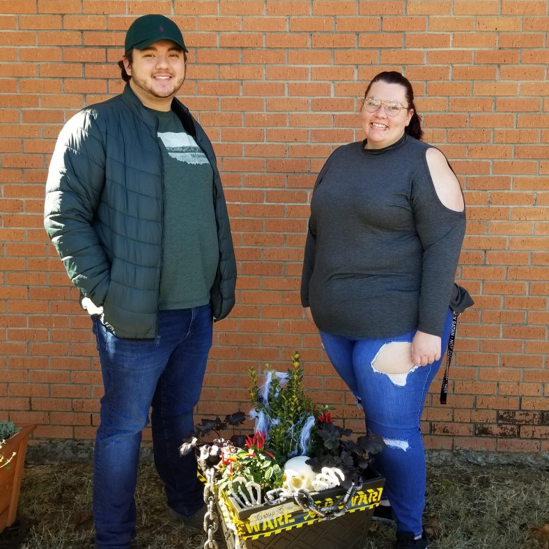 Two students stand with winning plant.