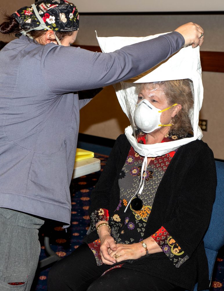 AllianceHealth Respiratory Therapist Candance Moya (left) fits Seminole State College President Lana Reynolds (right) with an N95 mask.