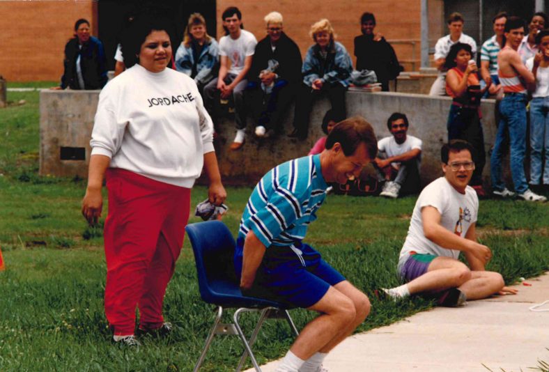 Former counselor Cynthia Yerby looks on as longtime business instructor Fred Bunyan tries to break a balloon during his Trojan Olympics contest.
