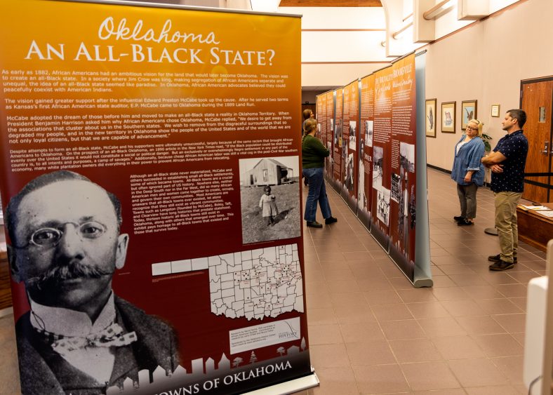 People are shown attending the All-Black Towns of Oklahoma historical exhibit on the first floor of Enoch Kelly Haney Center at Seminole State College of Oklahoma.