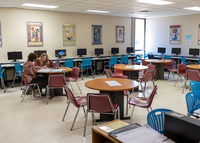 Two students study at a table inside one of SSC's classrooms.