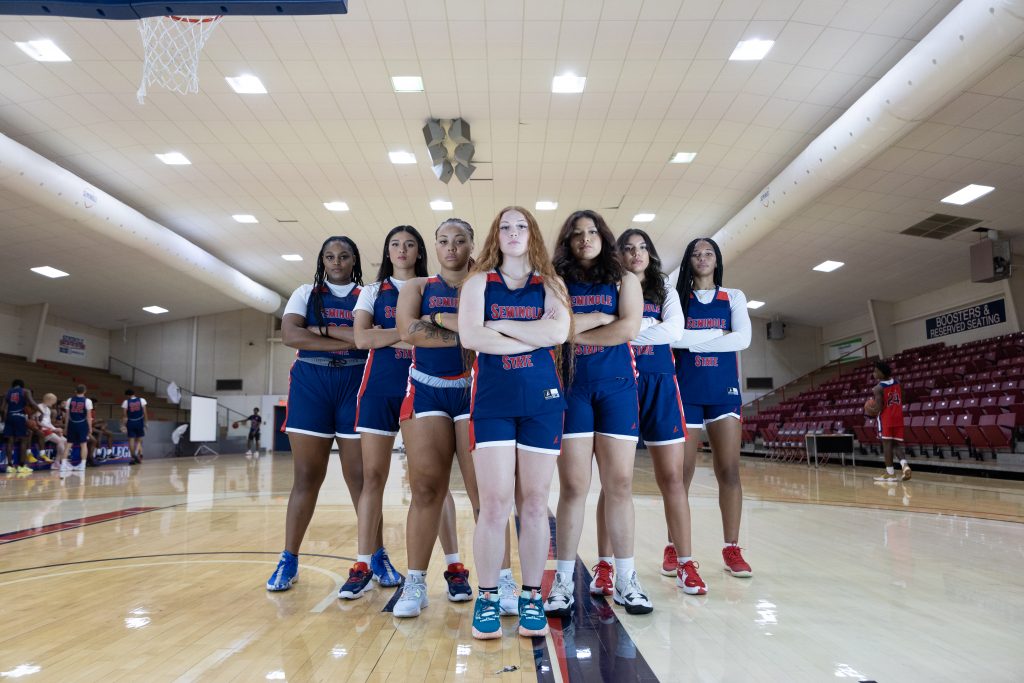 women's basketball team poses in gym