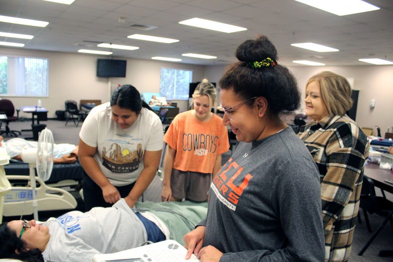 Nursing Program Director Crystal Bray (far right) directs students through a healthcare scenario in the nursing lab set to be renovated through the HRSA grant.