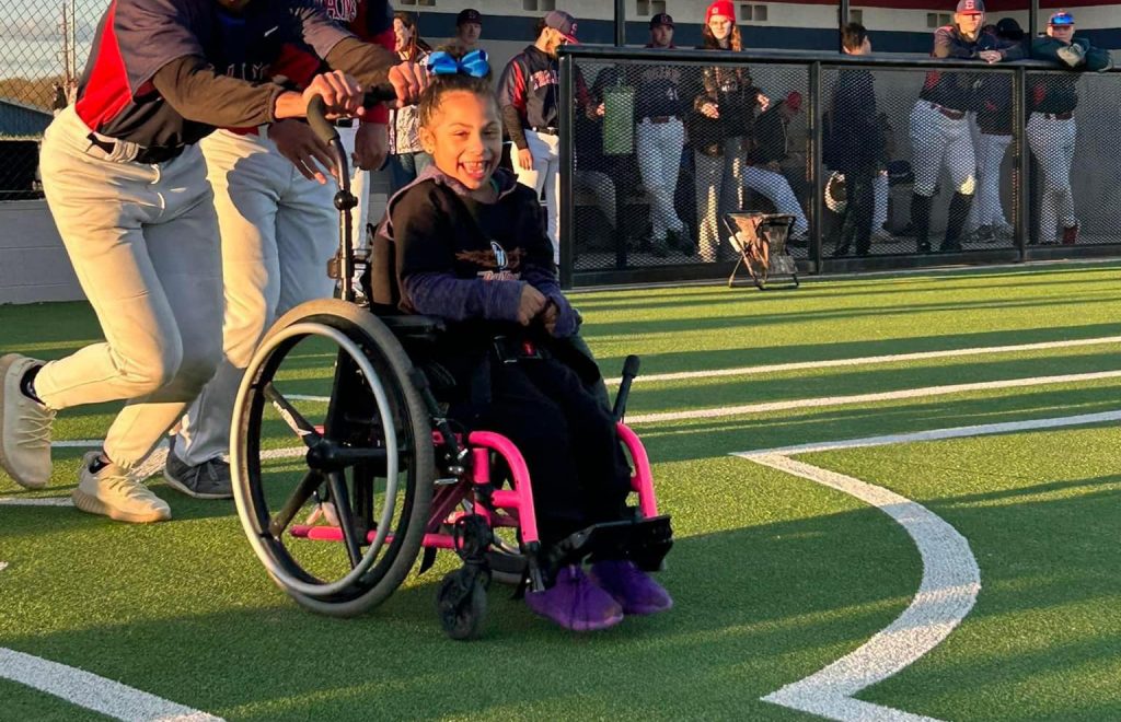 Pictured Khole Goodwin of Seminole makes her way to first base with two Trojan players.