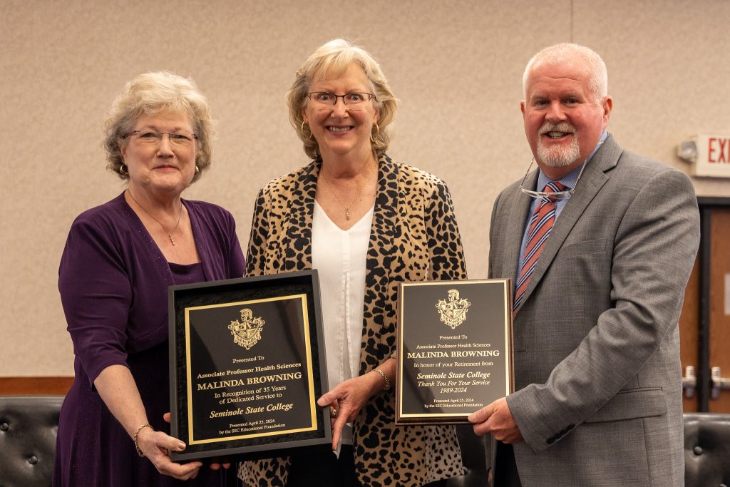 Posing for a photo on stage are SSC President Lana Reynolds (left) and SSC Educational Foundation Chair Lance Wortham (right) as they congratulate Medical Laboratory Technician Professor Malinda Browning (center) on her 35 years of service and her upcoming retirement.