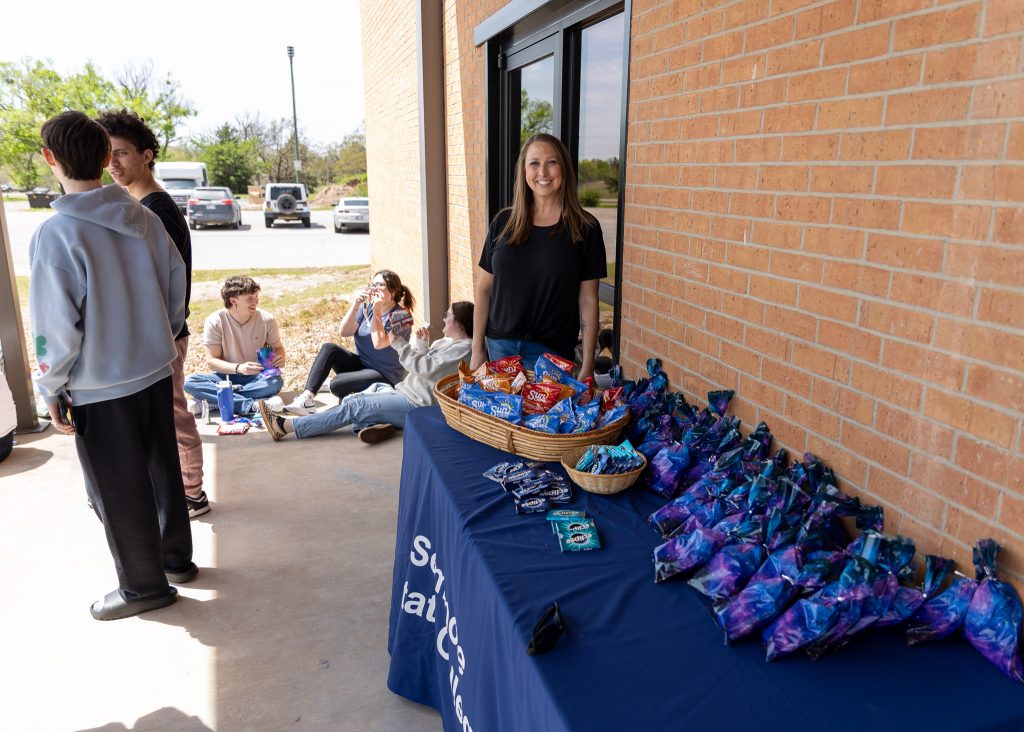 Pictured is Director of Student Activities and event organizer Melinda Sims passing out gift bags. Student Activities leaned into the theme and provided Sun Chips, Moon Pies, and Eclipse gum to attendees.
