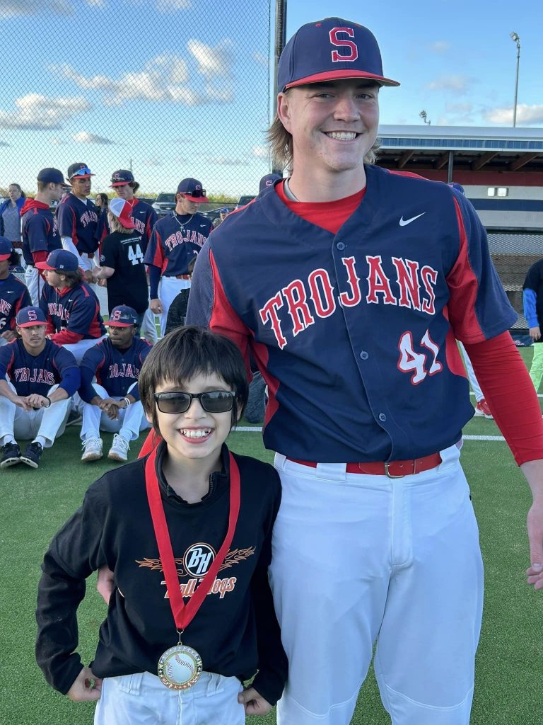 Pictured, Trojan baseball player Clayton Moore, of Norman, (right) congratulates A League of Their Own athlete Nic Tilley, of Seminole, for being named one of the game’s MVPs.