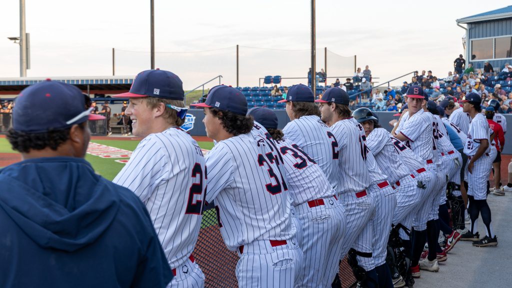In this photo, Trojan baseball team members are shown in the dugout during the recent tournament.