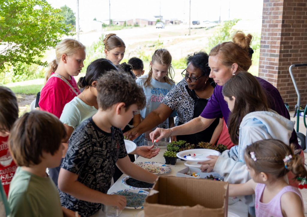In this photo, SSC Associate Professor of Agriculture Wendy Rich and Coordinator of Scholars in Excellence in Childcare Lynetta Robbins assist students in potting succulents during the Little Green Thumbs class.