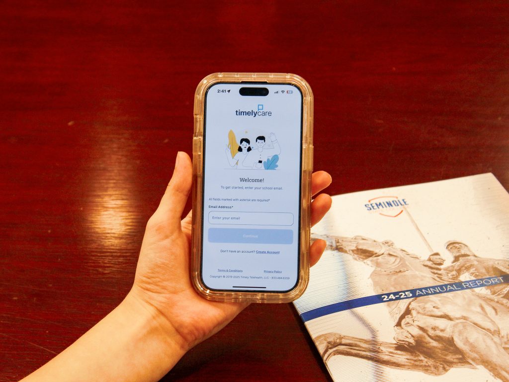 In this photo, A phone showing the TimelyCare app is the central focus.