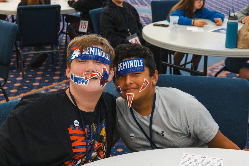 Two students wear SSC branded stickers across their faces.