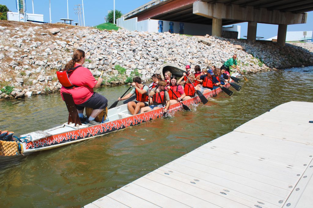 In this photo, students take part in the Dragon Boat Challenge on the Oklahoma River, working together to steer.