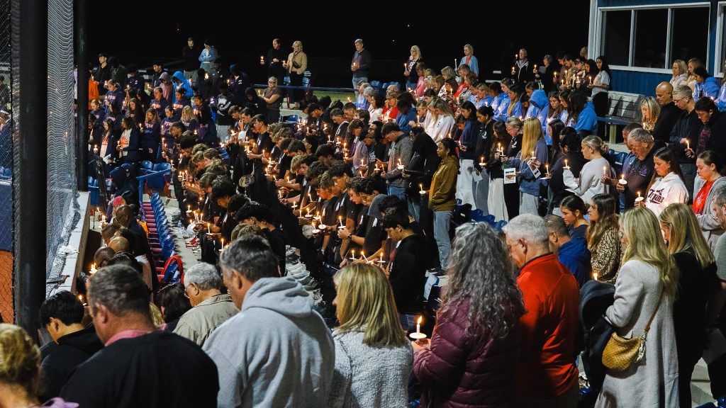 Crowd holds candles in honor of Denim Harris.