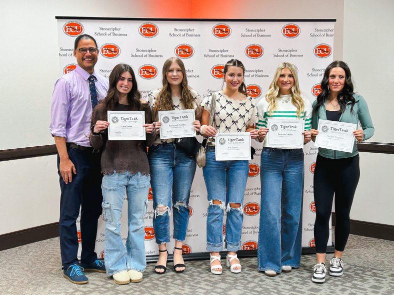 This is a group photo, pictured from left, Seminole State College Assistant Professor of Business and Entrepreneurs Club sponsor Brad Schatzel, Kara Doan of Frisco, Texas; Savannah Averitt of Seminole; Ava Freeze of Prague; Jentrie Gibson of Chandler; and Katie Simpson of Columbus, Kansas, gather at East Central University’s Stonecipher School of Business in Ada following the Tiger Tank and Tiger Trak business competitions Nov. 12.