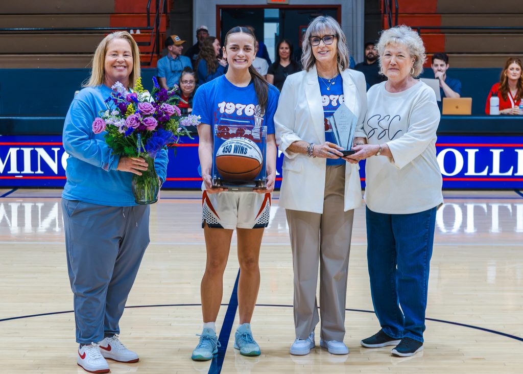 In this photo, pictured (left to right): Athletic Director Leslie Sewell, sophomore forward Alona Cooper-Rochovitz, Story-Schell and SSC President Lana Reynolds pose for a photo at half court commemorating Rita Story-Schell's 450th win.